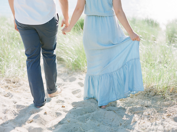 Couple walking hand and hand on the beach of South Haven, MI