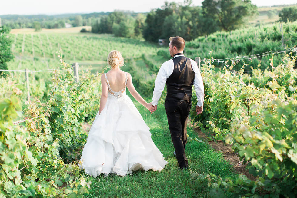 Couple walking through the vines after their Michigan elopment 