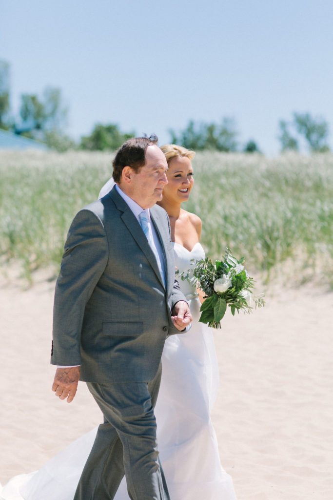 Bride walking down the aisle during her Lake Michigan beach wedding