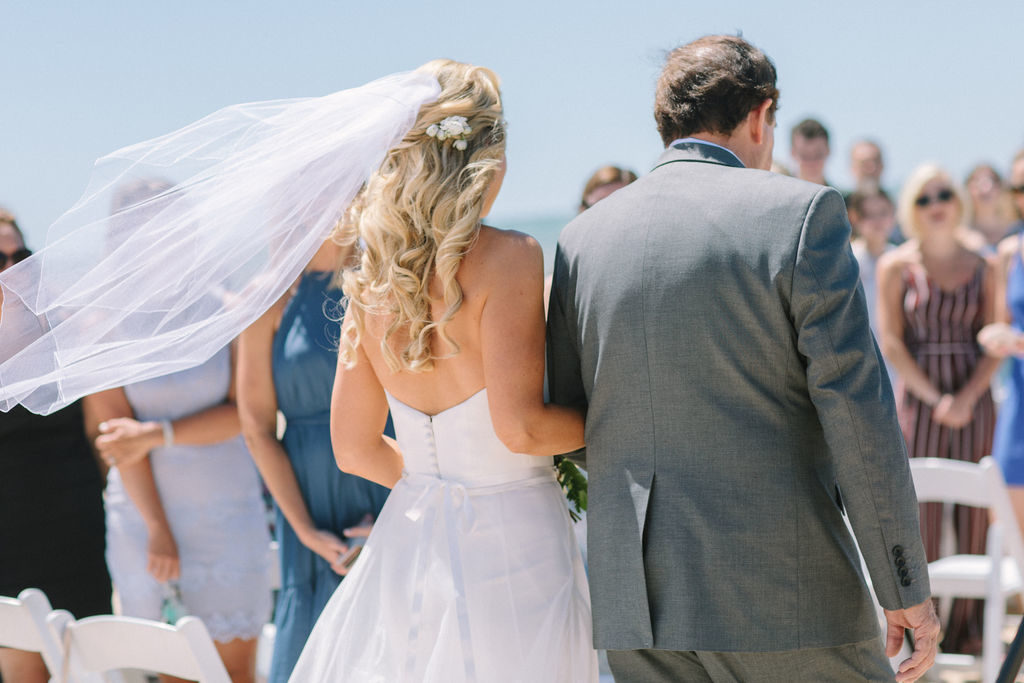 Bride's viel blowing in the wind during her Lake Michigan beach wedding