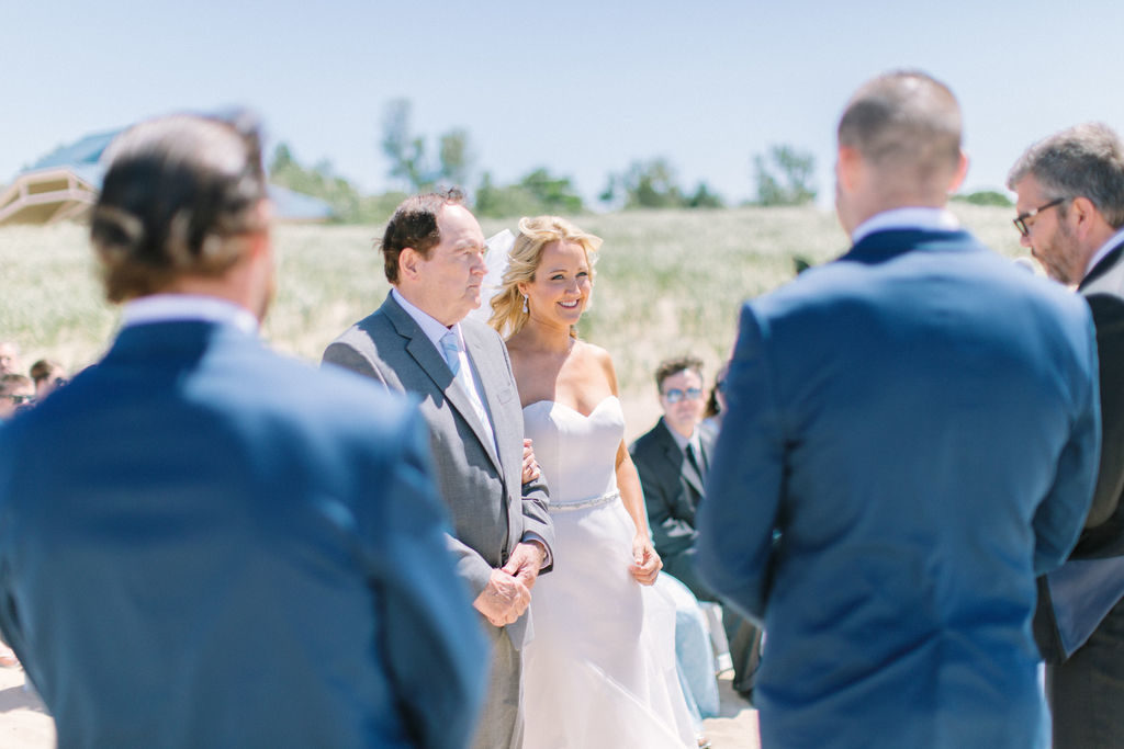 Bride smiling at her groom during their beach ceremony in Benton Harbor, MI