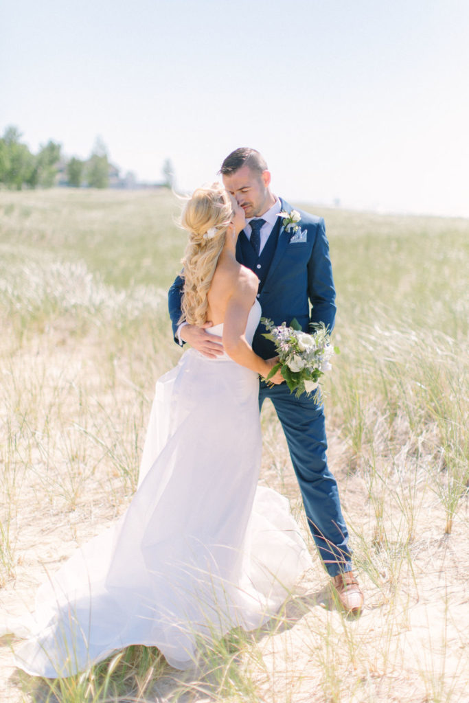 Newlyweds standing on the beach kissing