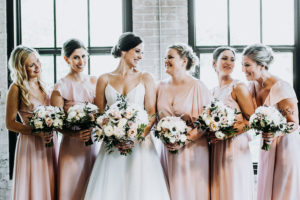 Bride and bridesmaids smiling at a Journeyman Distillery wedding