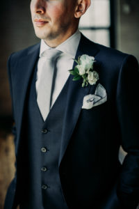 Navy groom's suit with a white boutonnière