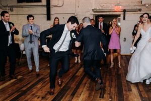Groom and groomsman dancing at a Journeyman Distillery wedding