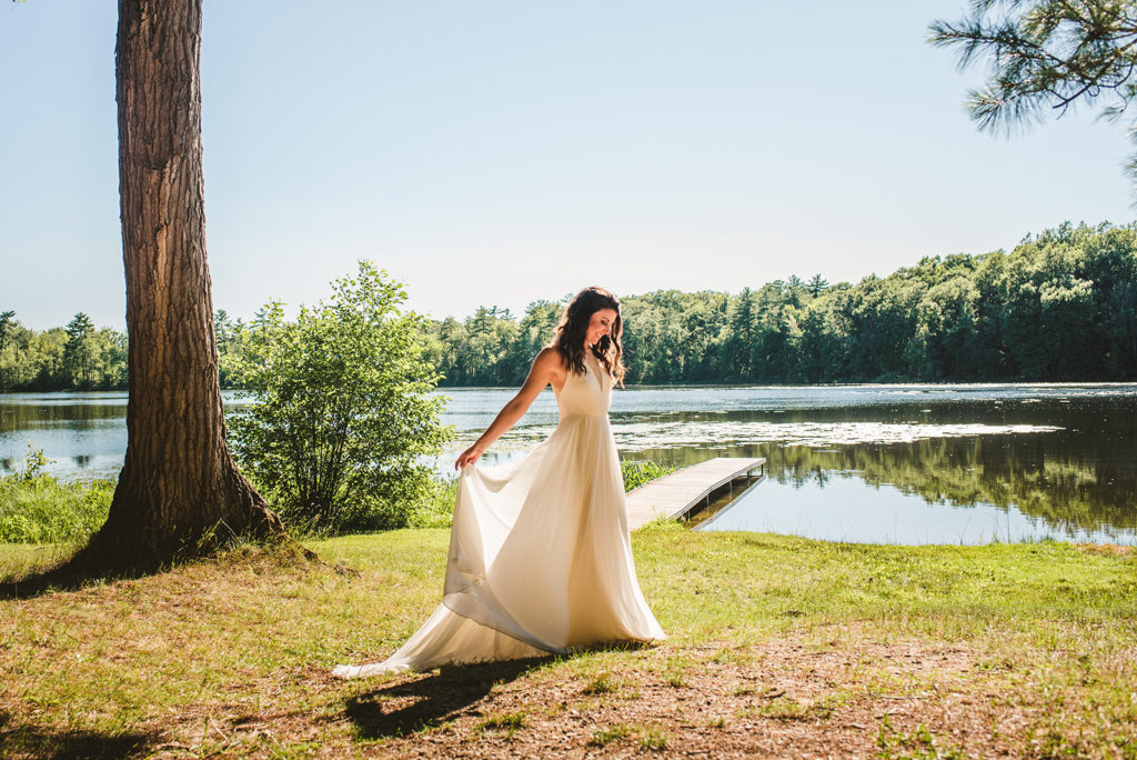 Bride smiling next to the lake at her Long Lake Outdoor Center wedding