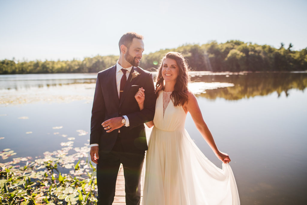 Bride and Groom smiling next to the lake at their Long Lake Outdoor Center wedding
