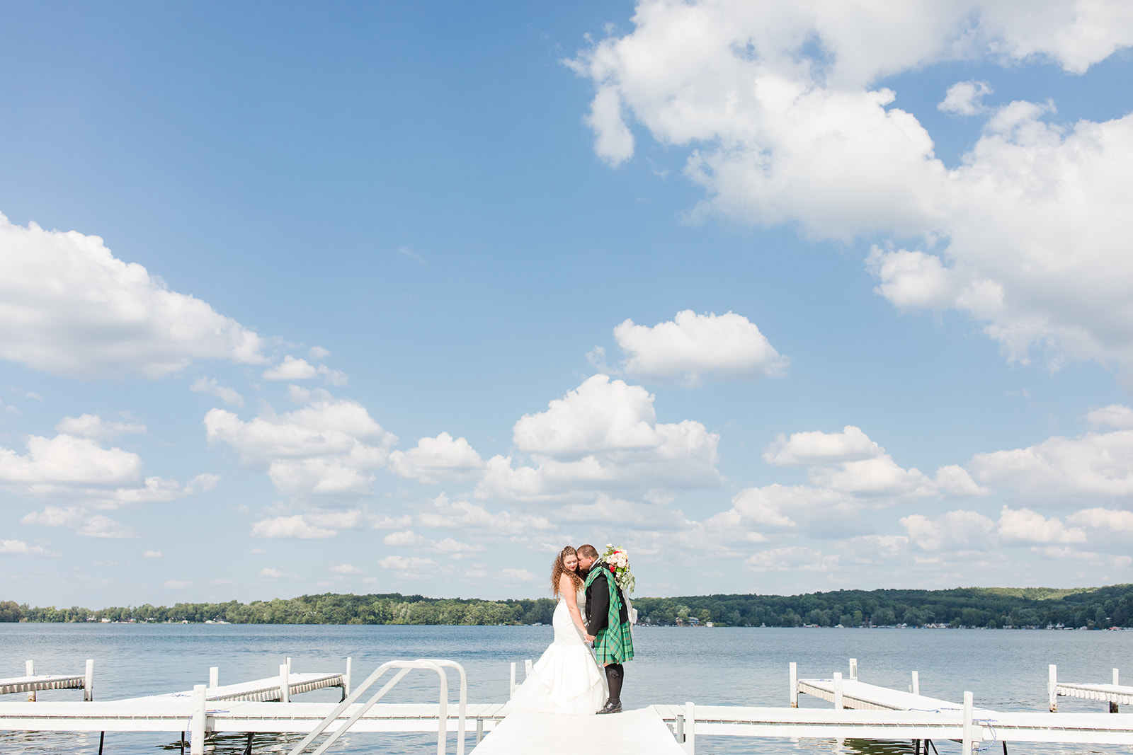 Newlyweds smiling on the docks during a Bay Pointe Inn wedding in Shelbyville, Michigan