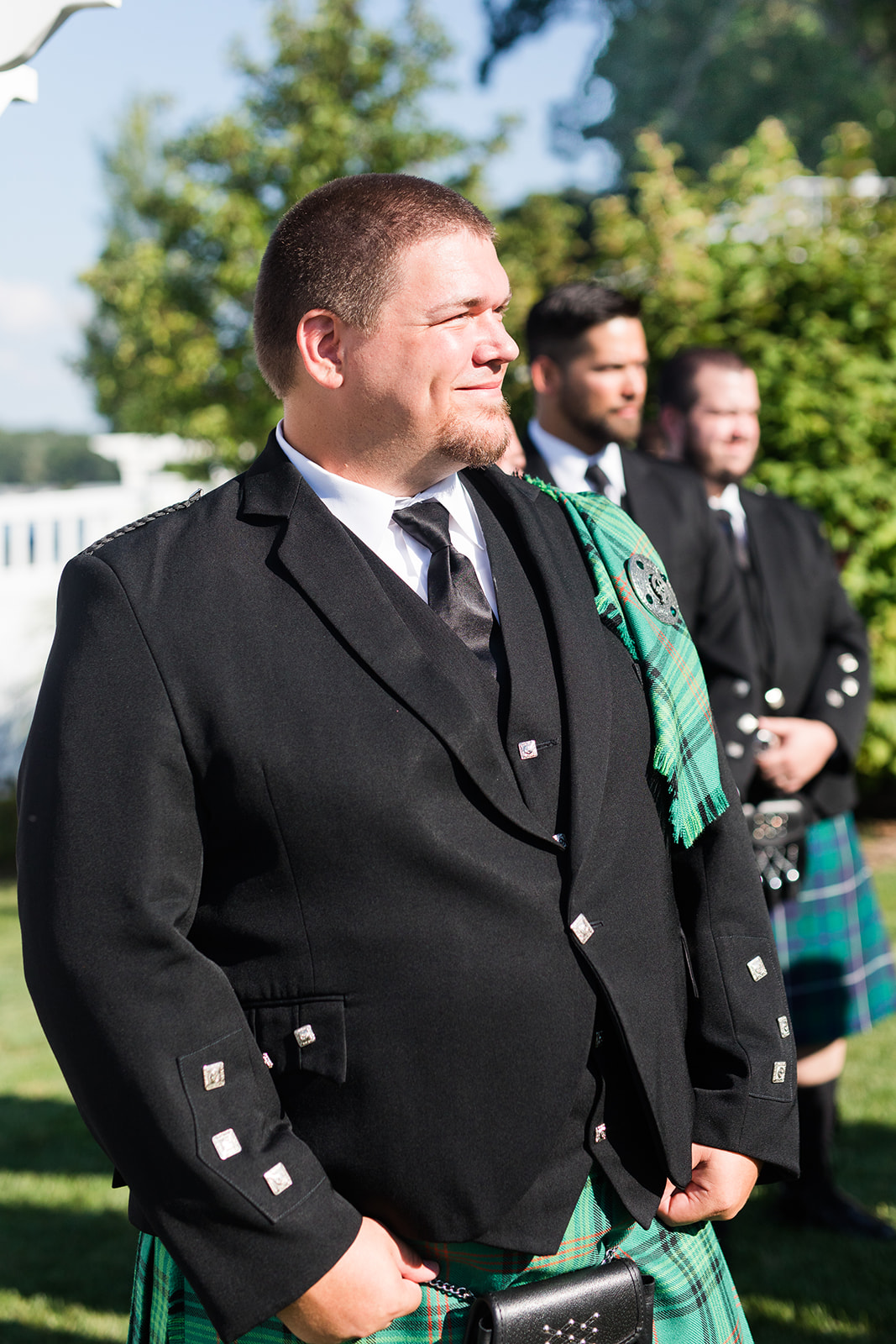 Groom smiling at his bride as she walks down the aisle 