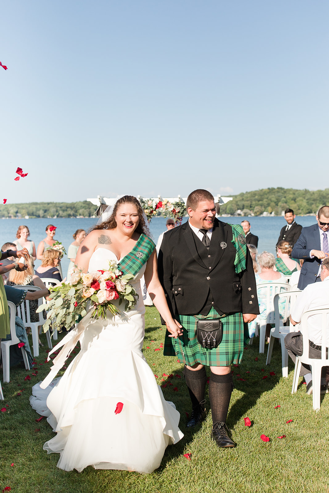 A rose petal toss during a lakeside wedding