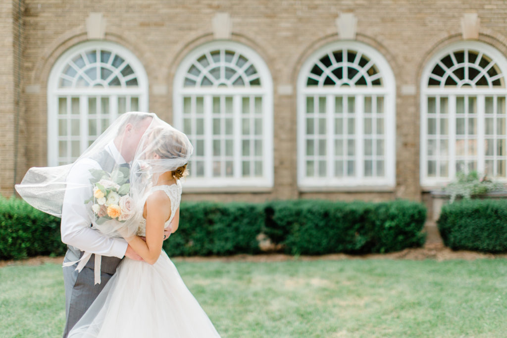 Bride and groom kissing outside at their felt mansion wedding