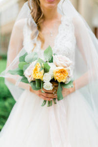 Bride holding a pink, yellow, orange and white bridal bouquet