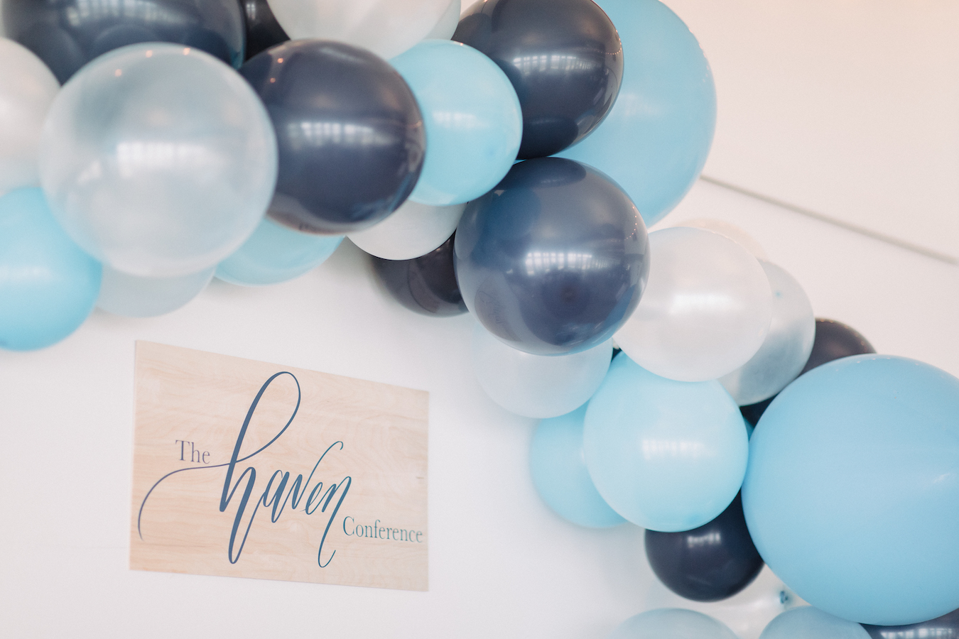 Blue balloon arch with The Haven Conference logo