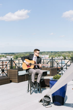 A musician playing guitar before a Sky Deck wedding in Kalamazoo, Michigan