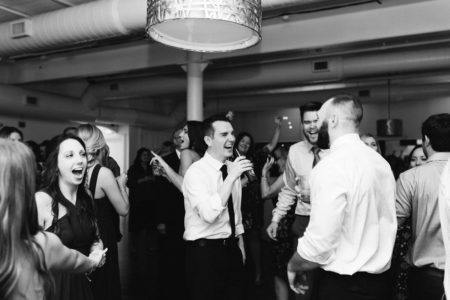 A groom laughing on the dance floor during his Kalamazoo, Michigan wedding