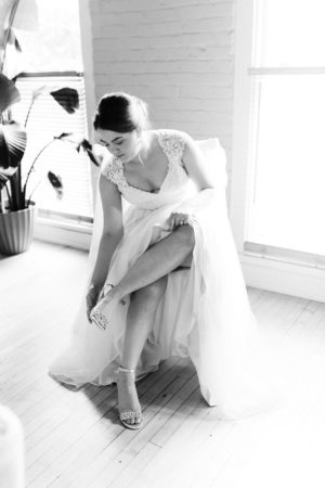 A bride putting on her wedding shoes before her Loft 310 wedding
