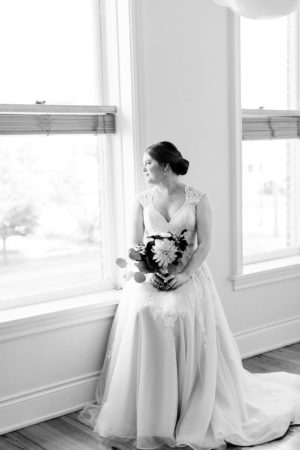 A bride looking out the window before her Kalamazoo, Michigan wedding