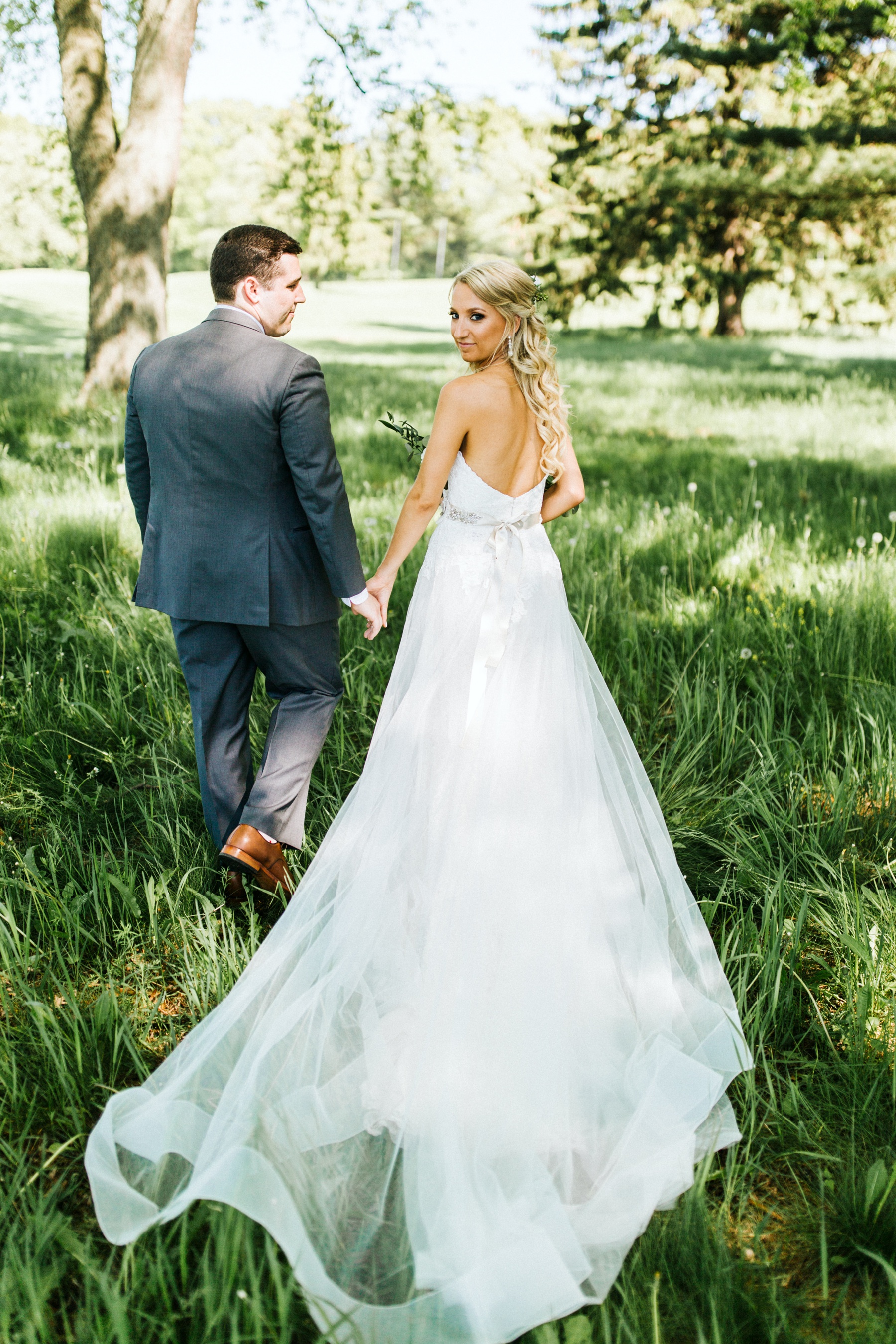 A bride and a groom walking outside before their spring lake country club wedding