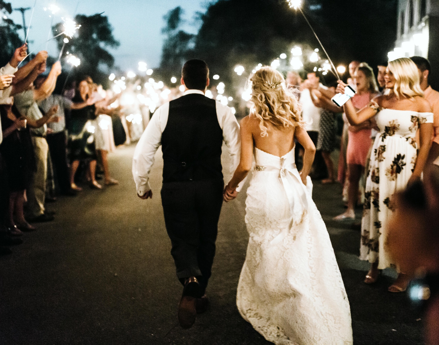 A couple walking through sparklers during their spring lake country club wedding