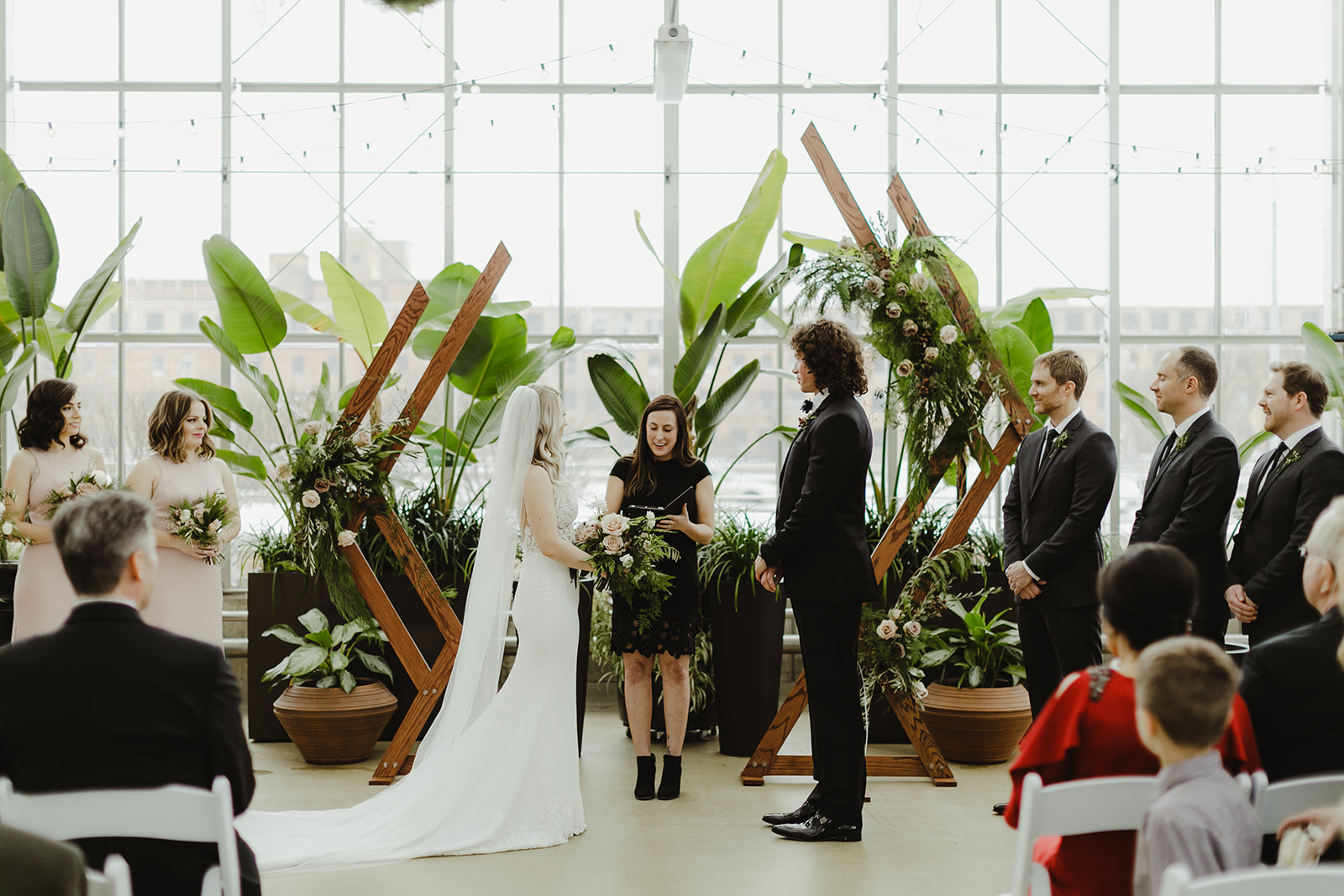 A couple and wedding party enjoying a ceremony during a Downtown Market Grand Rapids wedding