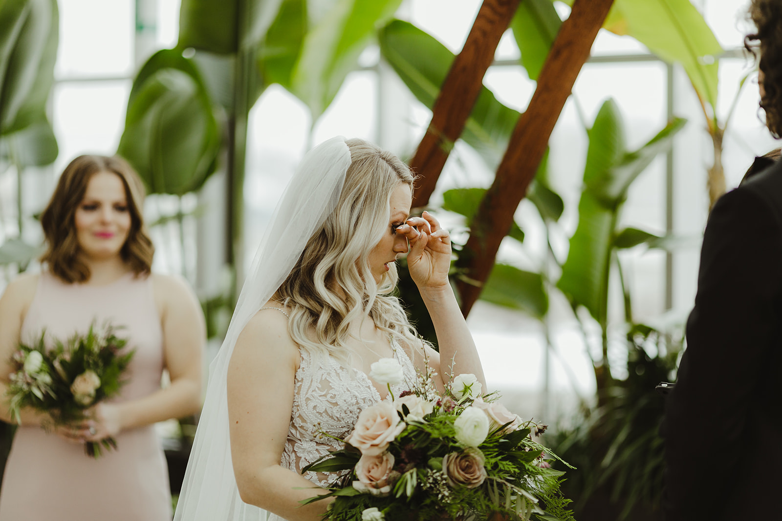 A bride wiping her tears during her wedding ceremony