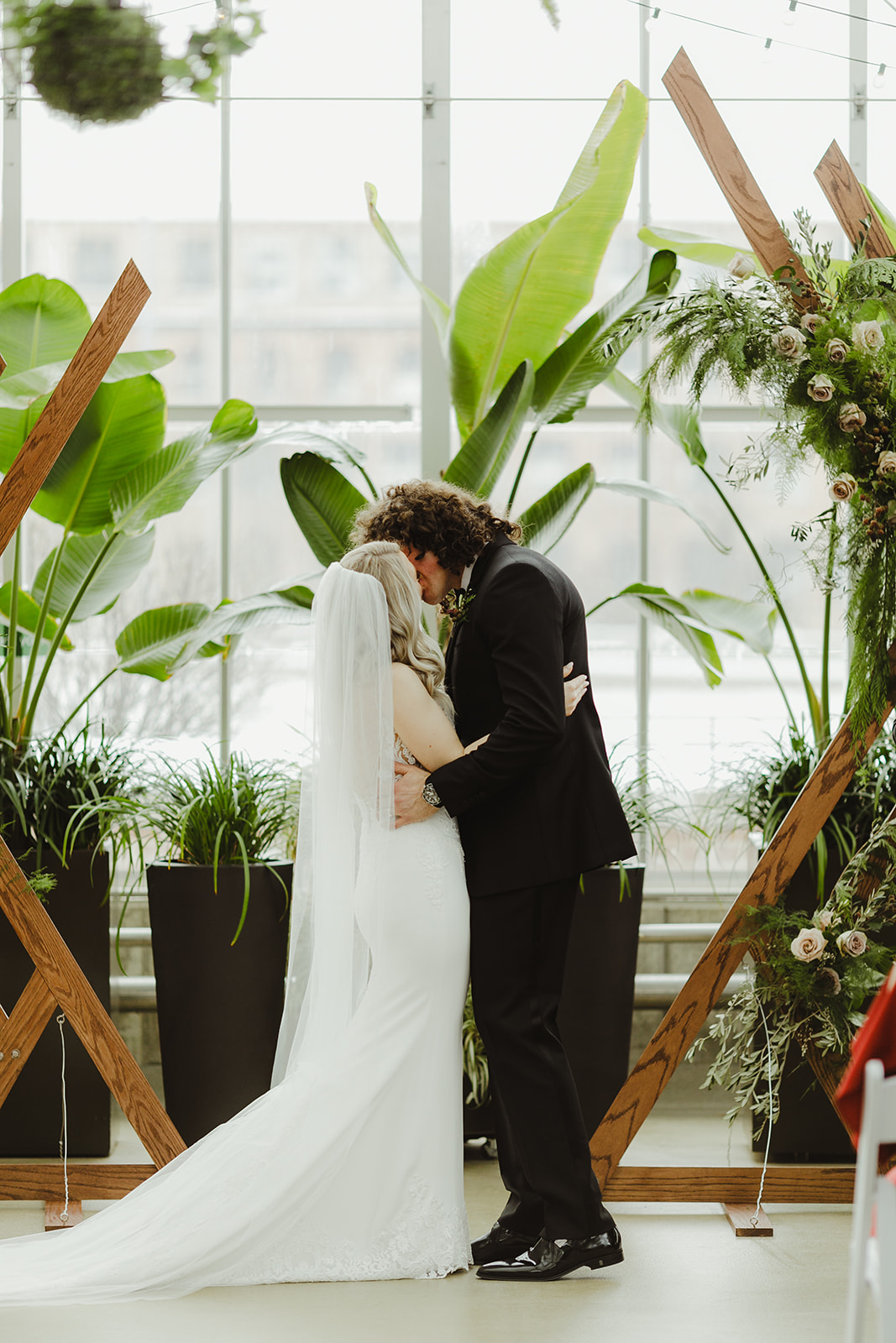 A couple sharing their first kiss during their Downtown Market Grand Rapids wedding