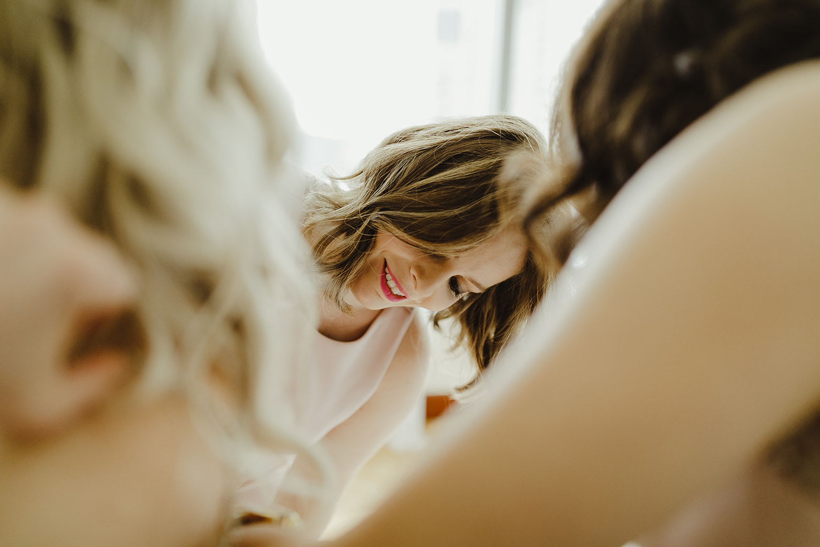 Bridesmaids zipping up a brides dress