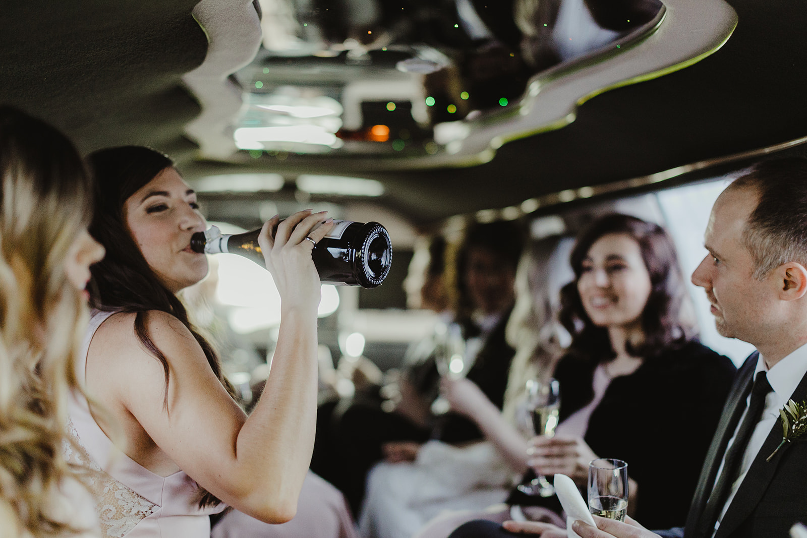 A wedding part celebrating in a limo after a wedding ceremony