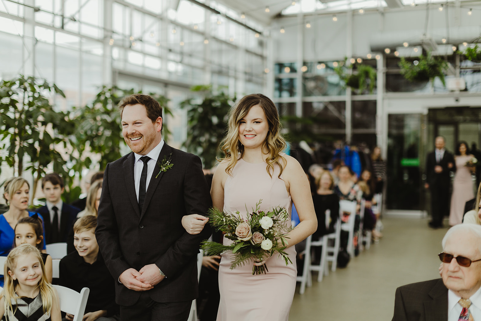 Wedding party members walking down the aisle during a Downtown Market Grand Rapids wedding