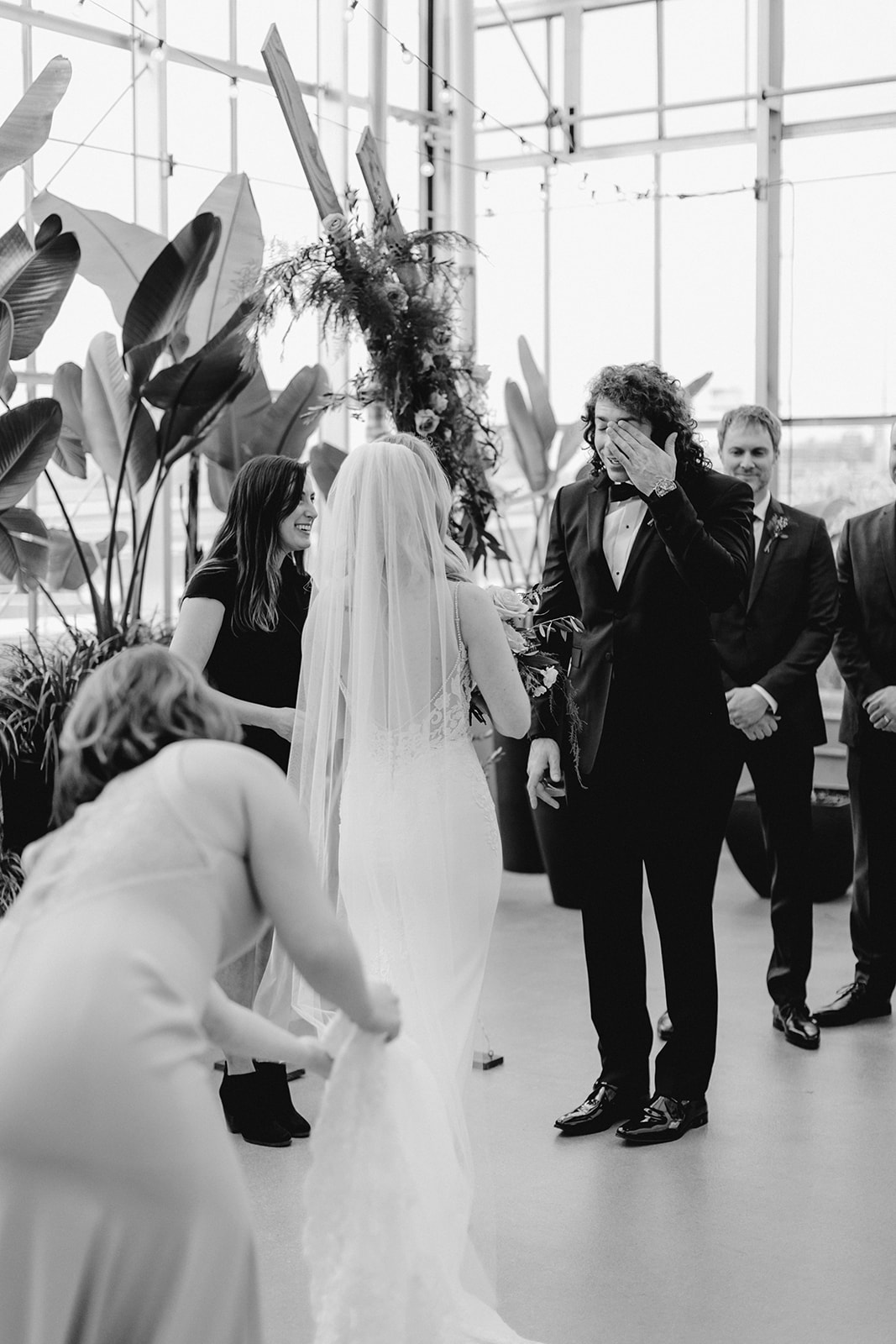 A groom crying as he reads his vows