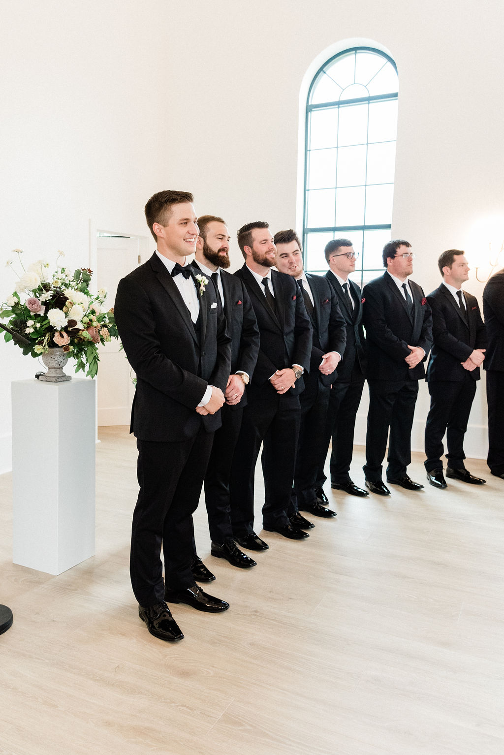 Groom and groomsmen smiling during a wedding