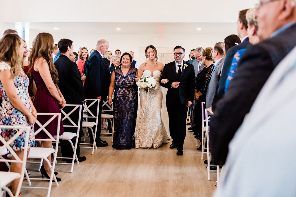 Bride walking with her parents down the aisle during her Kalamazoo, Michigan wedding