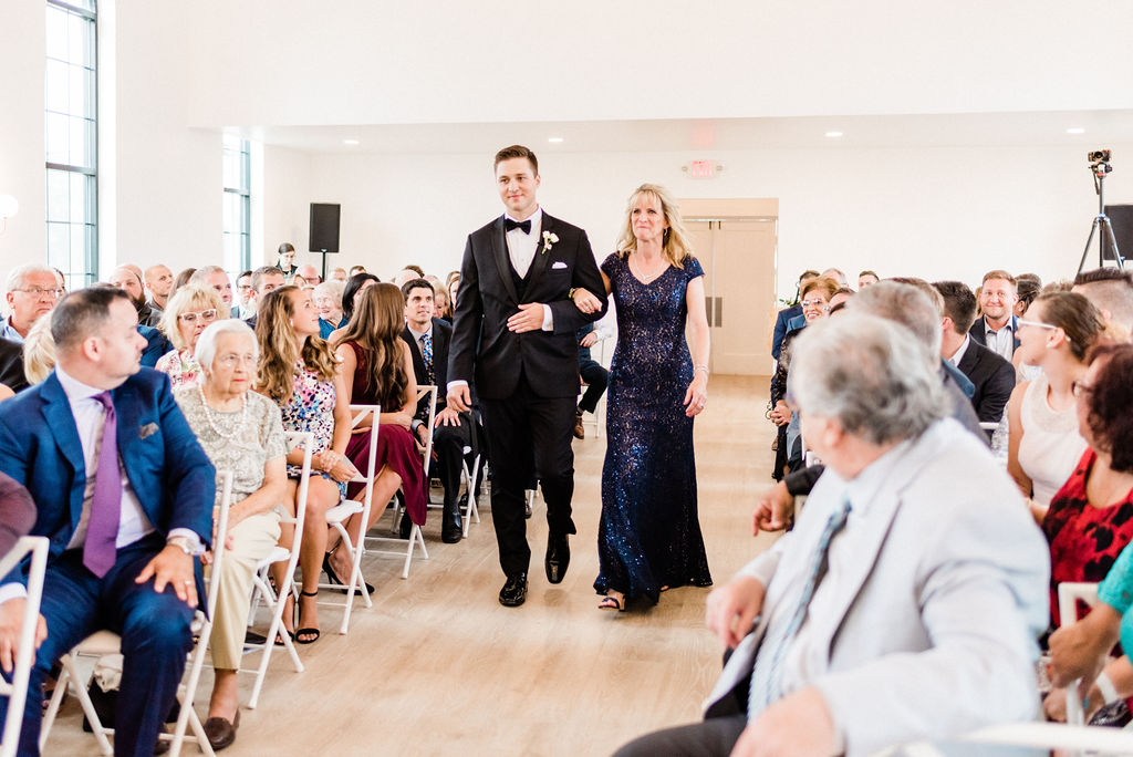 Groom walking his mom down the aisle during his Kalamazoo, Michigan wedding