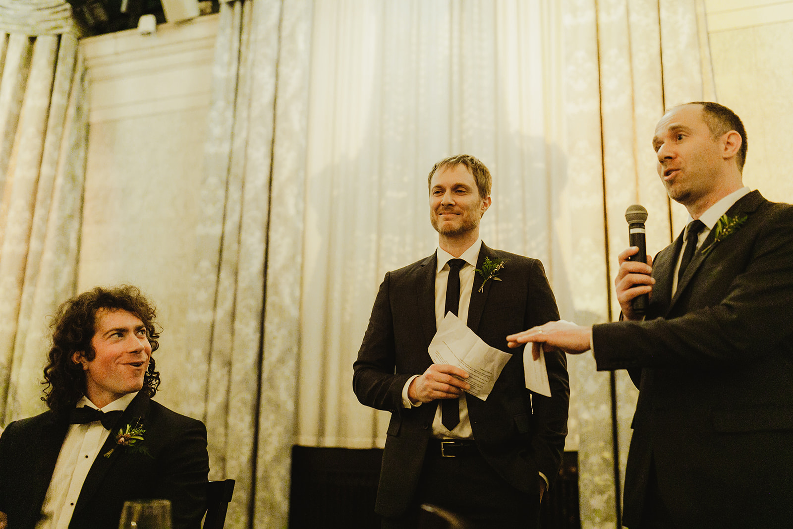 A groom and his best men sharing speeches during his wedding