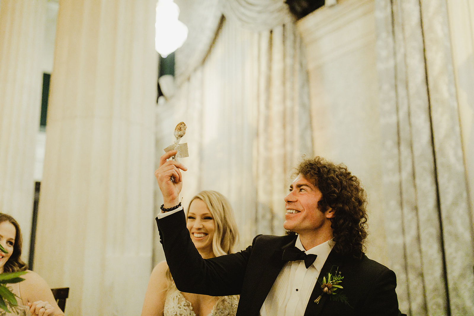 A groom smiling and holding up a spoon