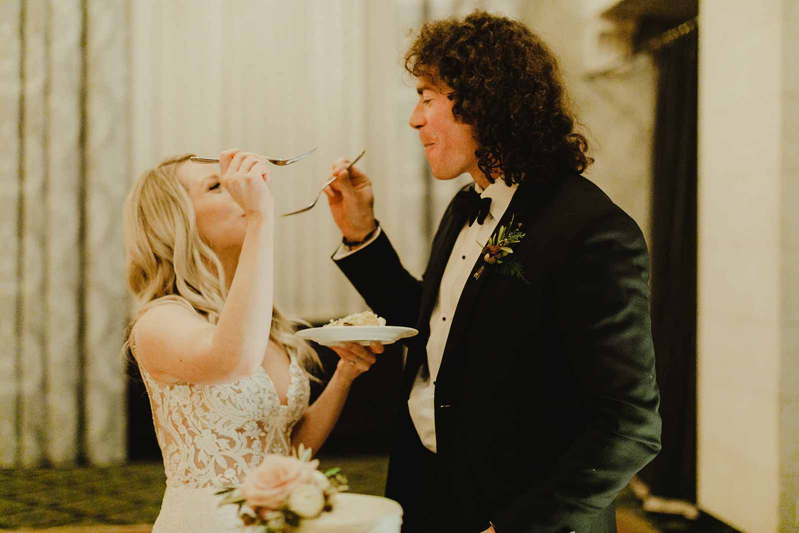 A couple feeding each other cake during their Grand Rapids, Michigan wedding
