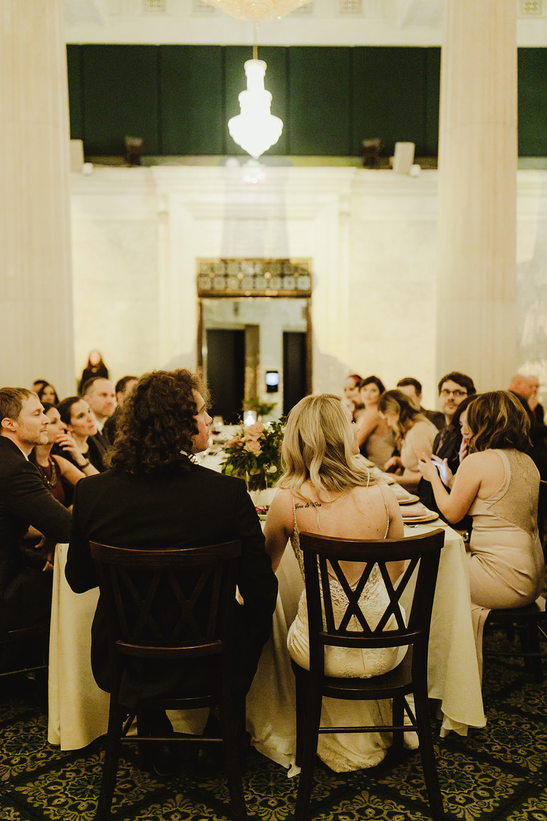 A couple enjoying speeches during their Ballroom at McKay wedding