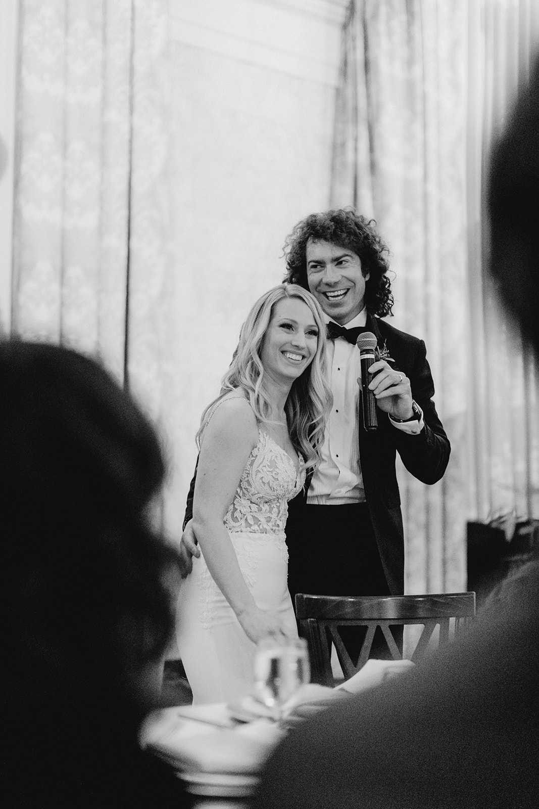 A couple smiling during speeches at their Grand Rapids, Michigan wedding