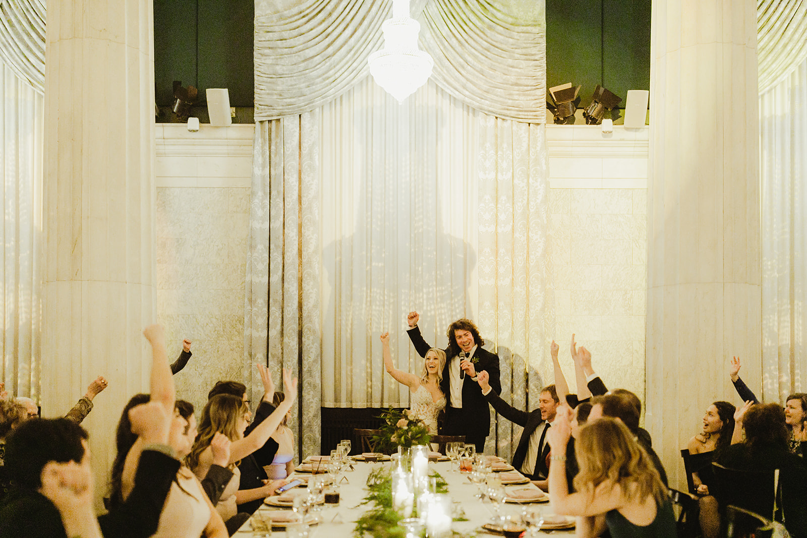 A couple cheering during their Ballroom at McKay wedding