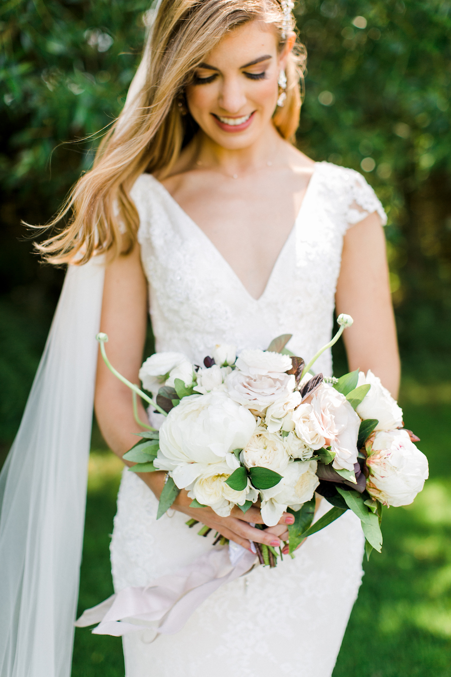 A bride smiling at her bouquet