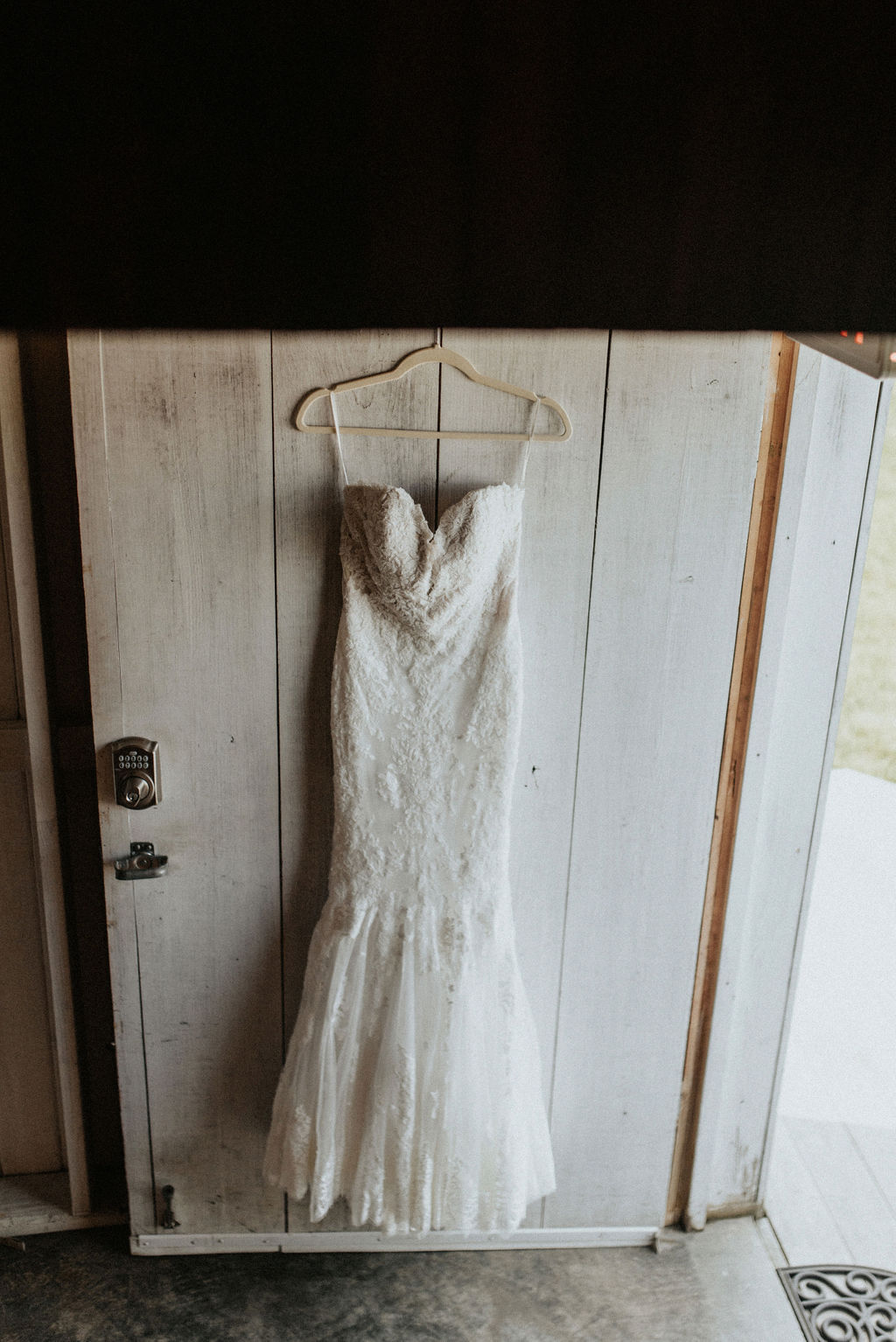 A bridal gown hanging on a barn door.