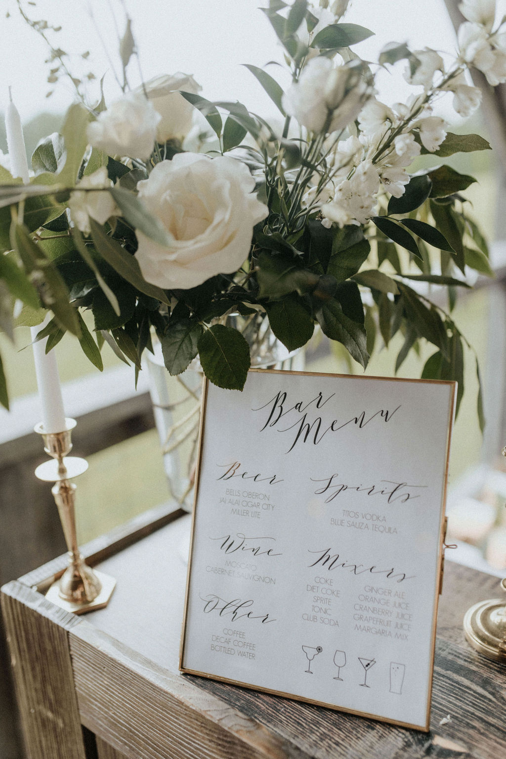 A bar menu with white flowers and greenery.