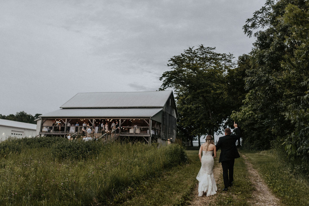 A couple walking to their Hidden Vineyard Wedding Barn wedding