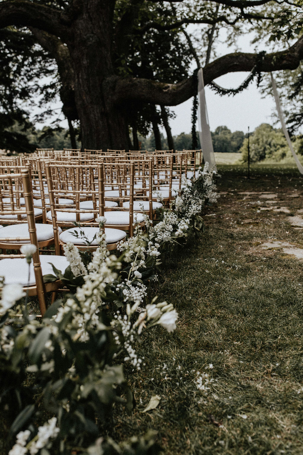 Flowers lining the edge of the aisle at an outdoor ceremony