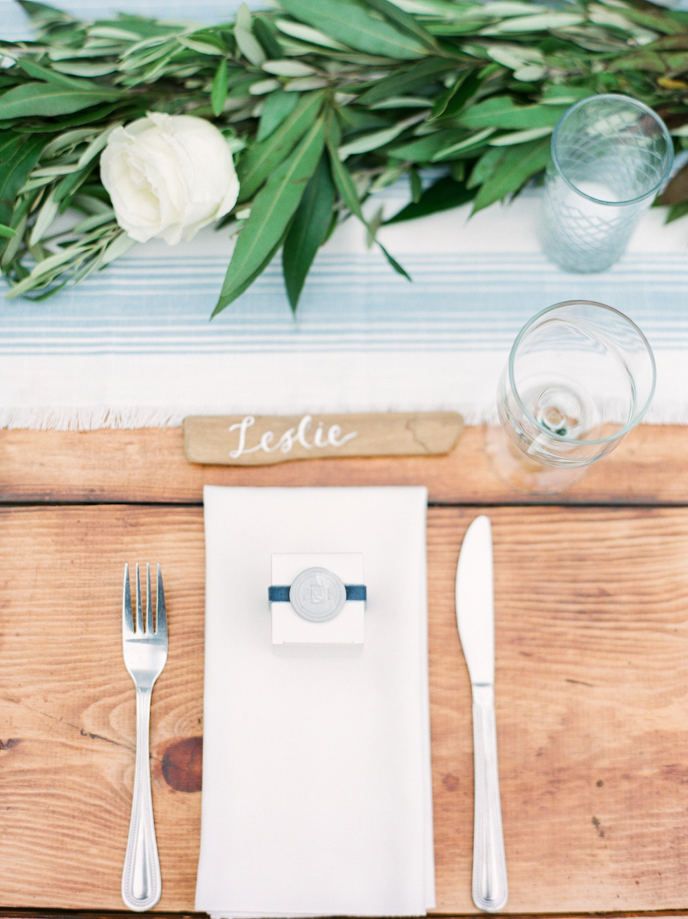 A driftwood escort card during a beach wedding