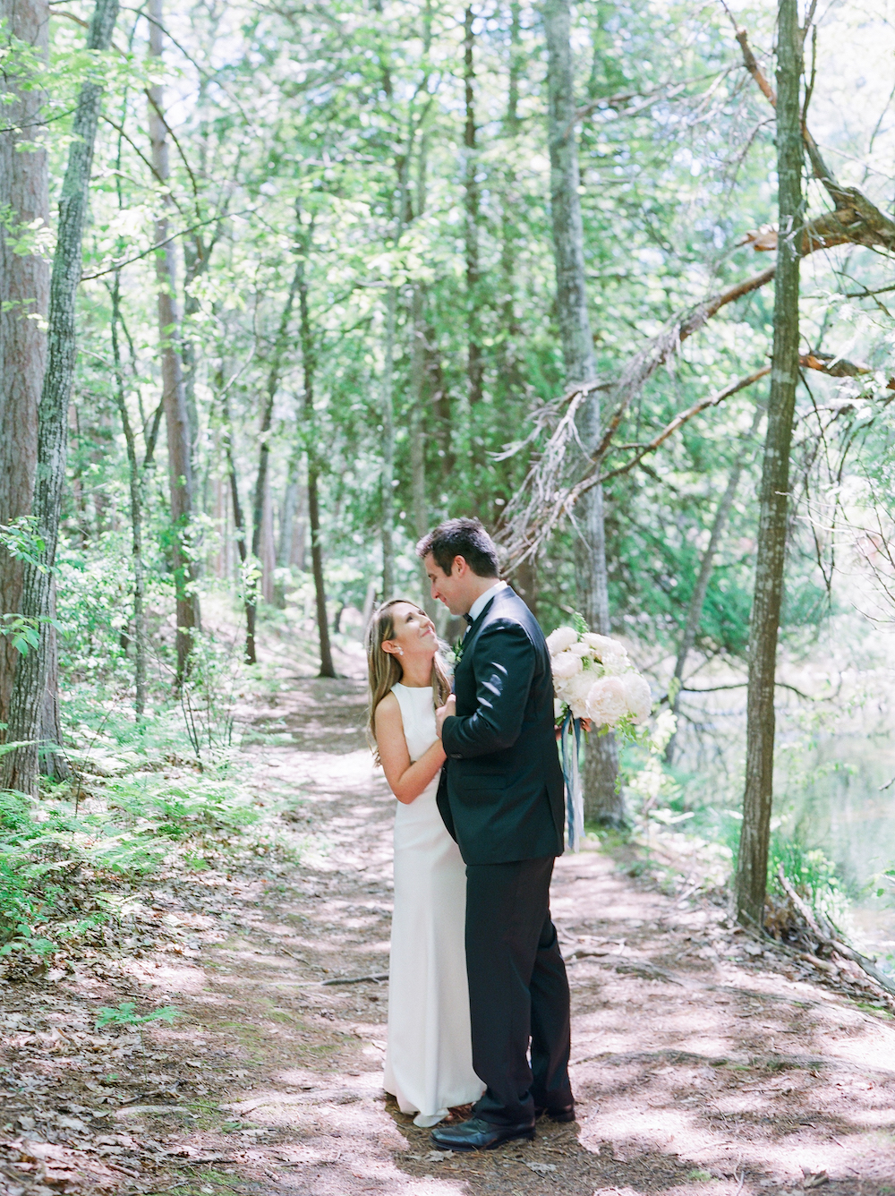 A bride and a groom in the woods on their wedding day