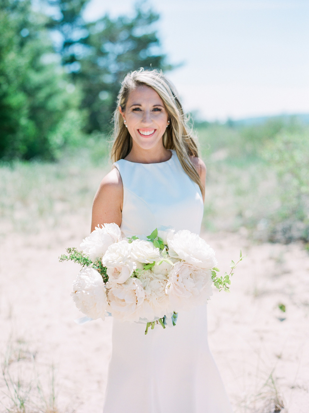 A bride smiling during her beach wedding