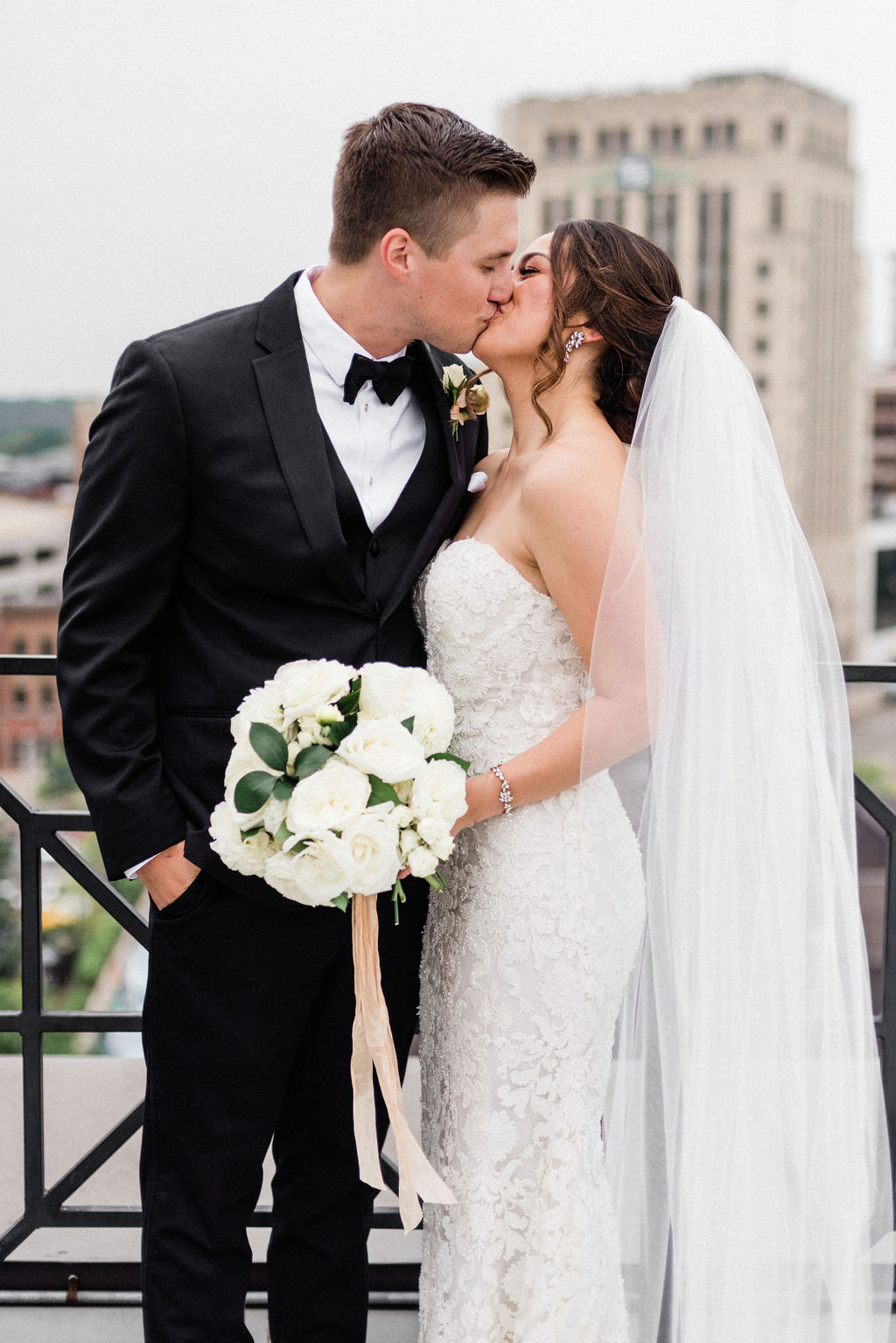 A couple sharing a kiss before their downtown kalamazoo wedding