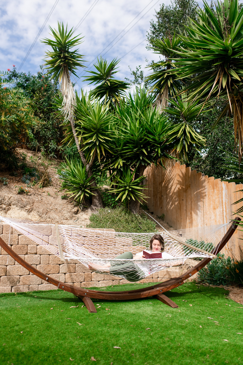 A woman reading a book in a hammock 
