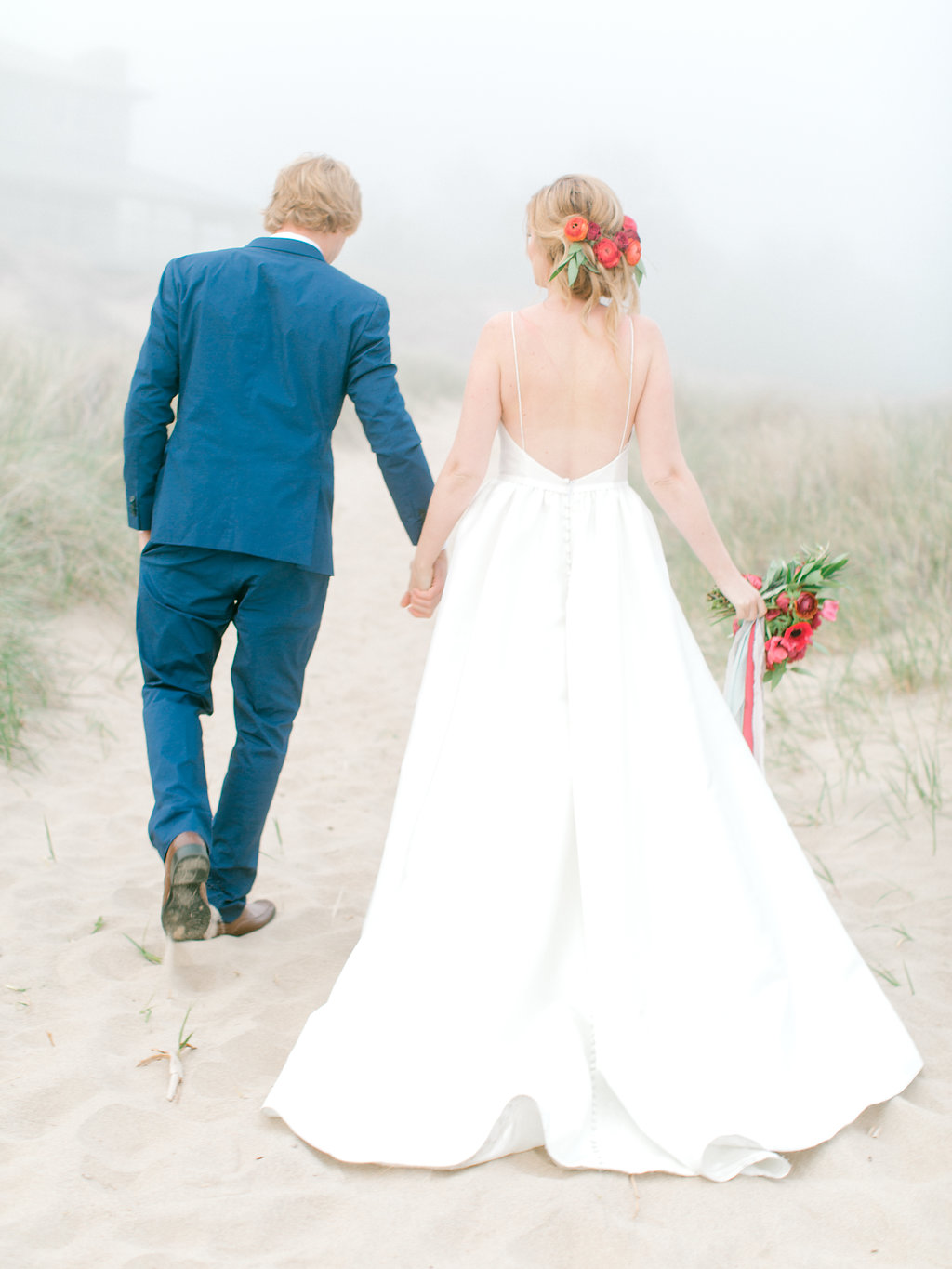 Couple holding hands during their beach wedding in Michigan